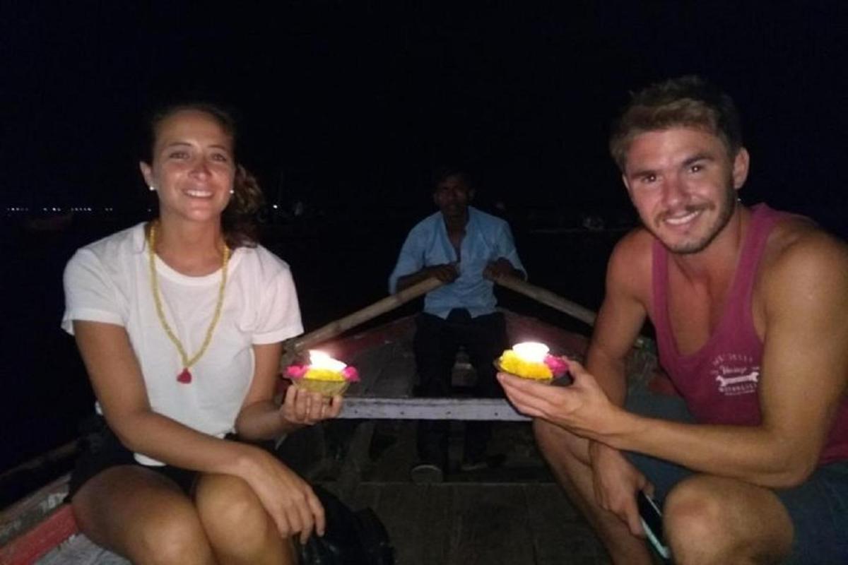 Un hombre y una mujer sosteniendo dos postres con velas encendidas.