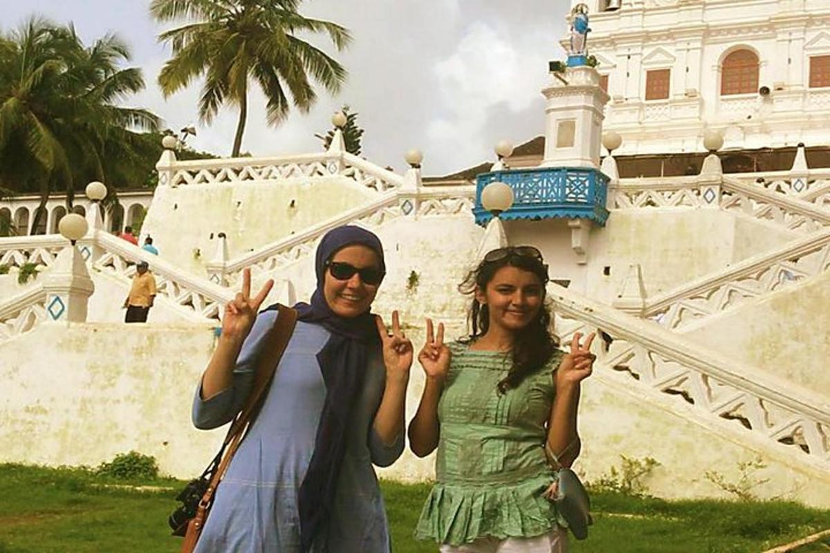 duas mulheres fazendo o sinal da paz em frente a um prédio