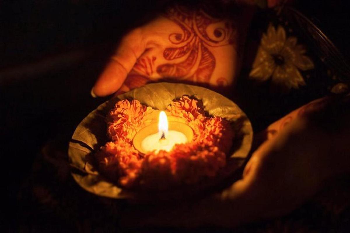 seseorang yang memegang lilin kecil dalam balutan