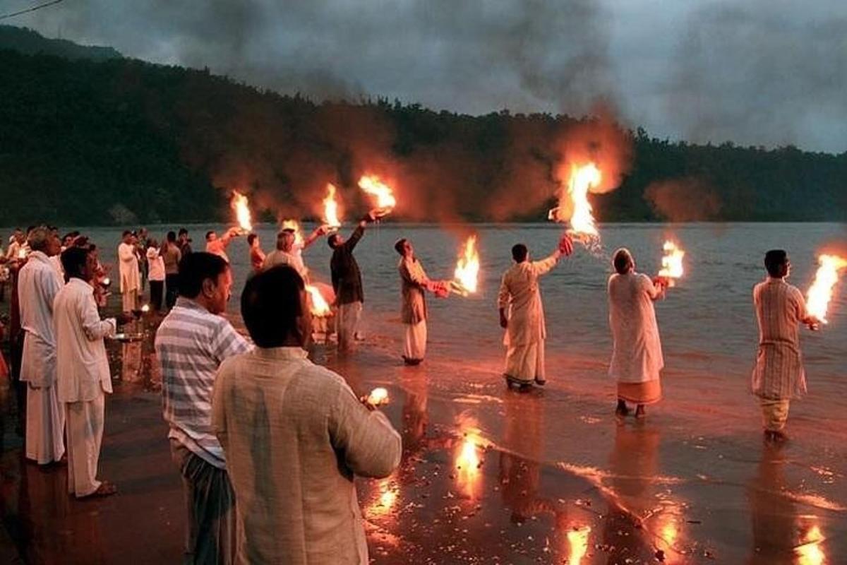 sekumpulan orang berdiri di dalam air dengan obor