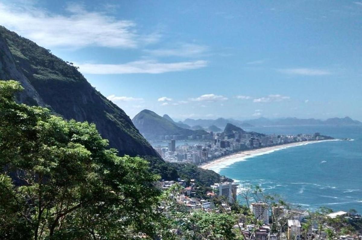 a view of the city and the ocean with mountains