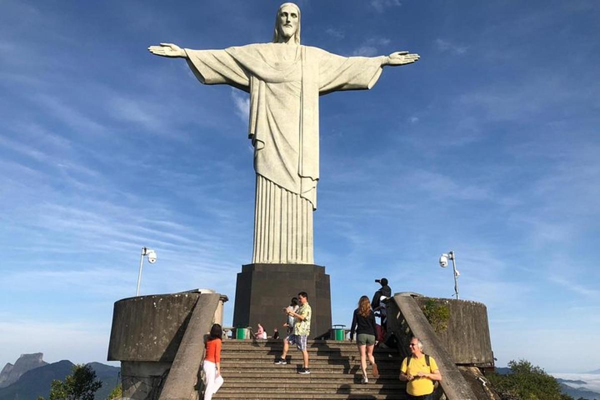 a group of people standing around the statue of christ the redeemer
