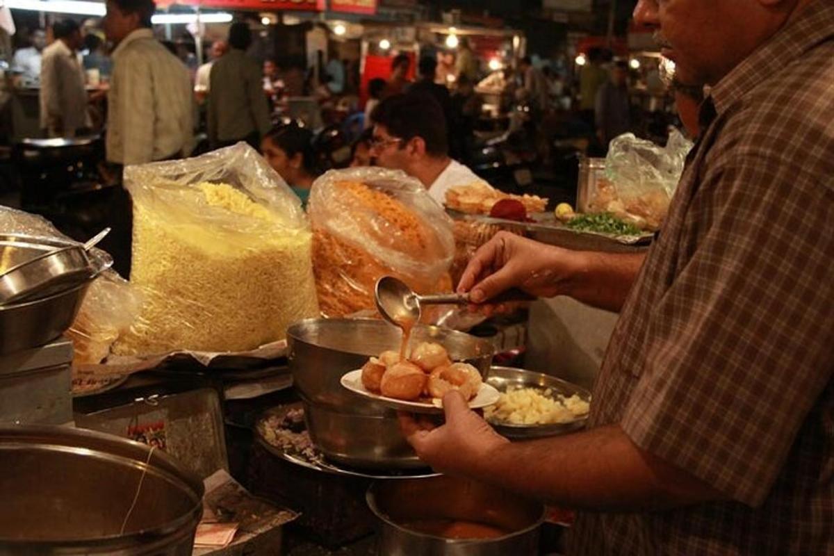 a man holding a plate of food in a kitchen