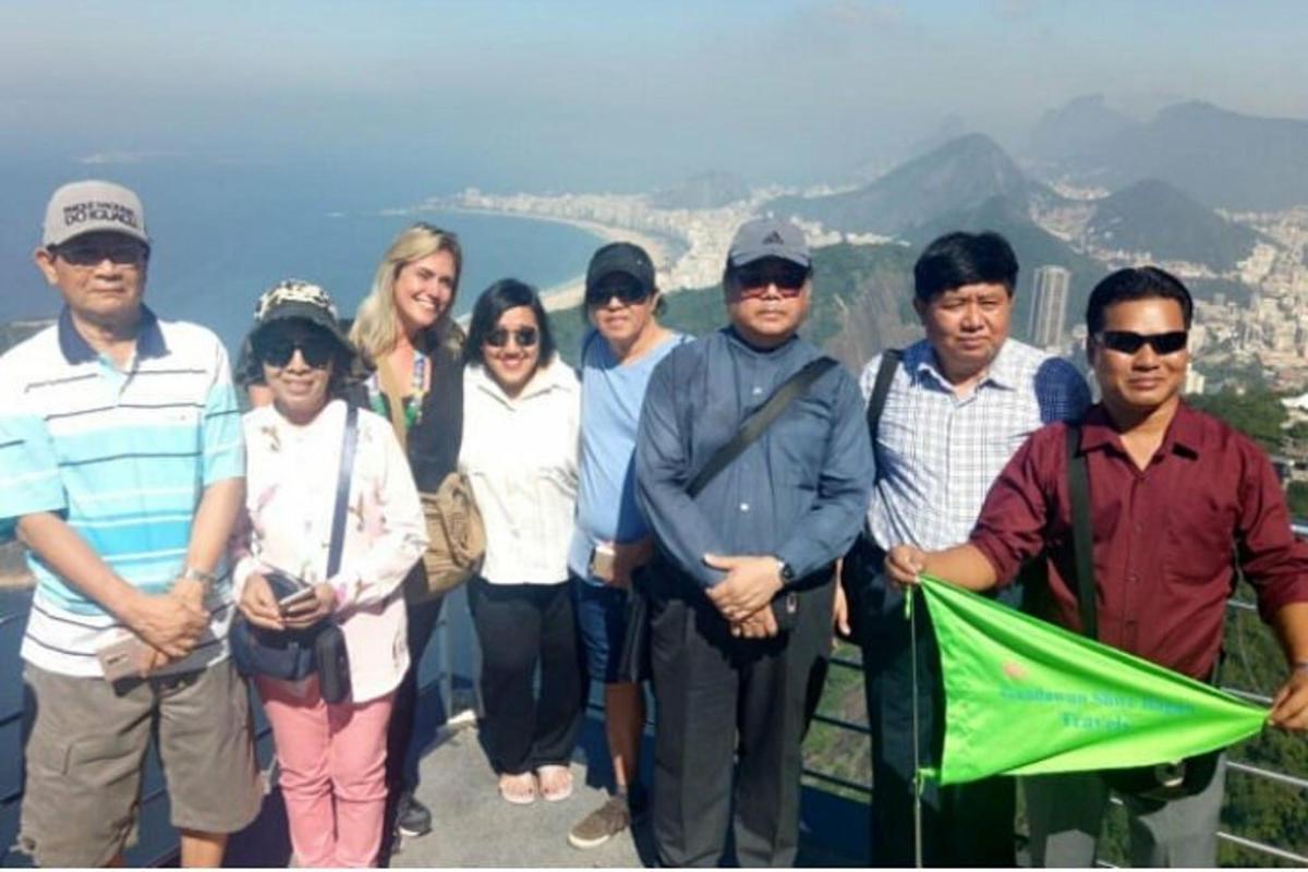 a group of people posing for a picture on a mountain