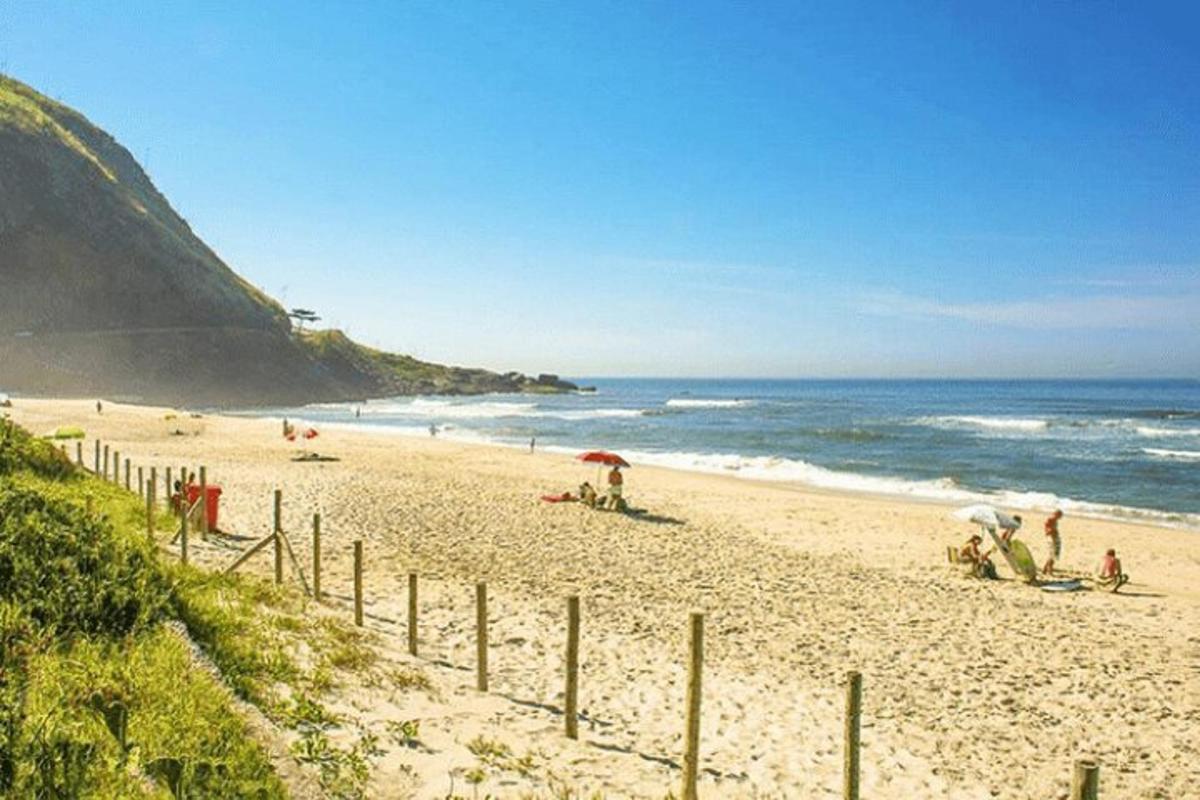ein Strand mit Menschen im Sand und im Meer