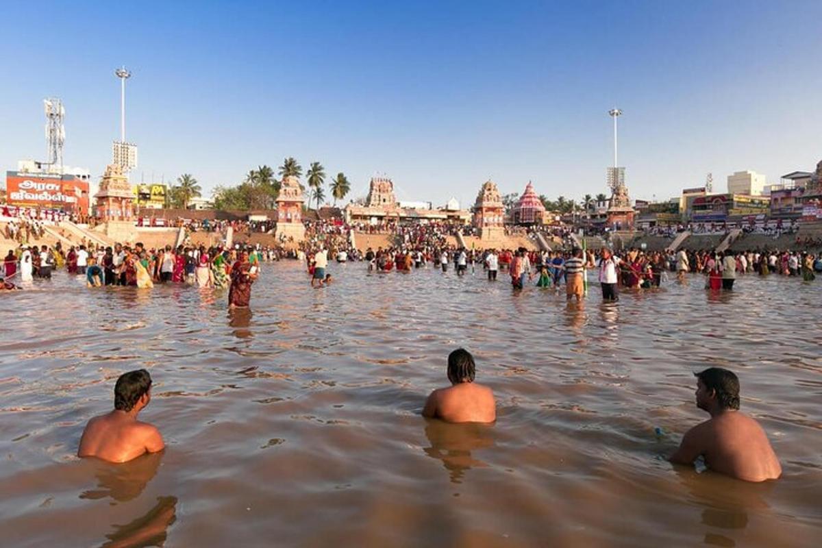 three men sitting in the water in a city