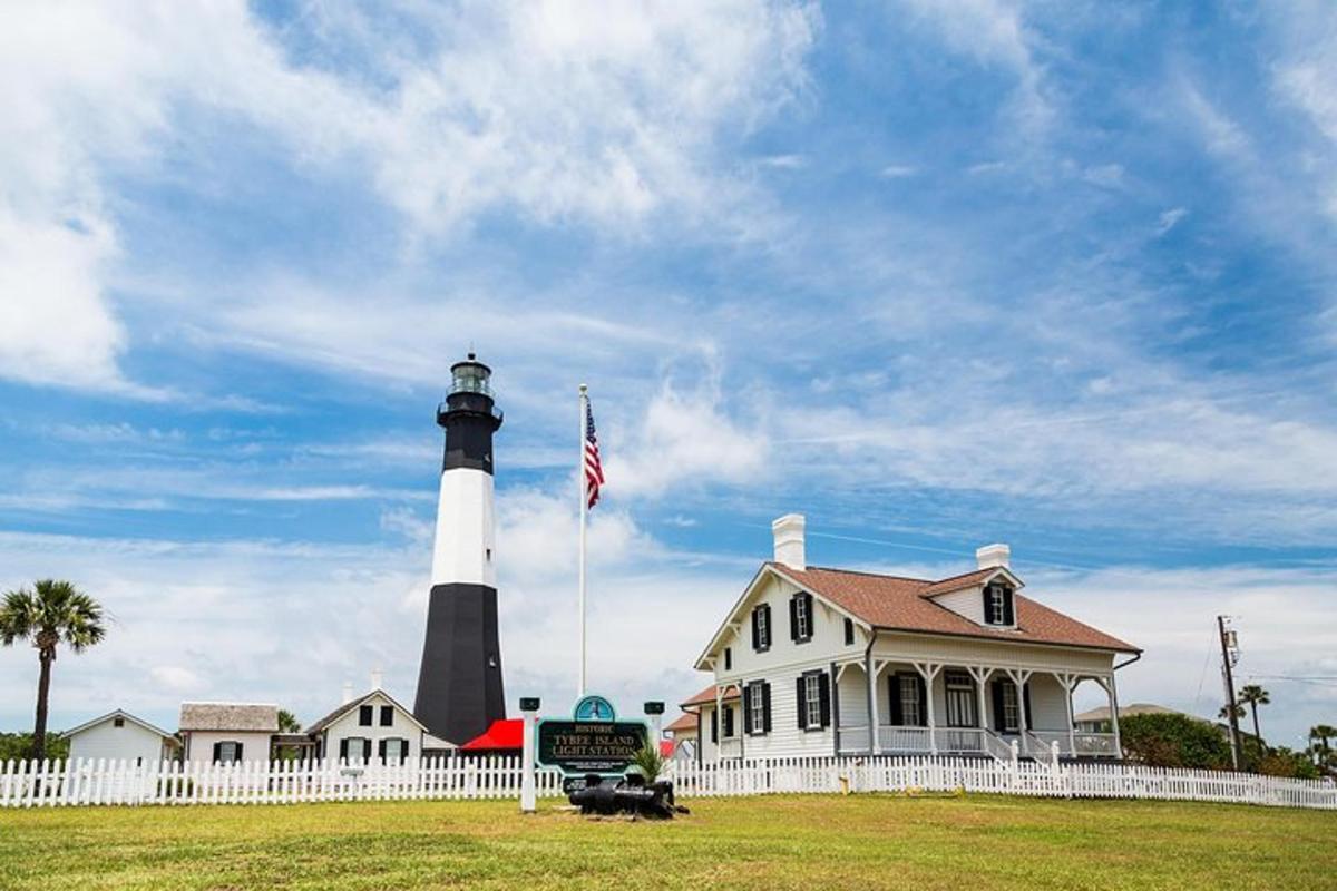 a lighthouse in front of a house with a flag