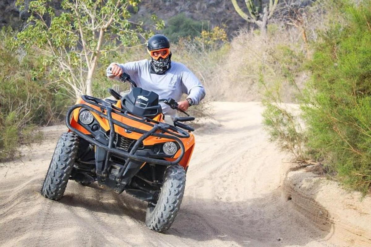 un home que condueix una moto de cross per un camí de terra
