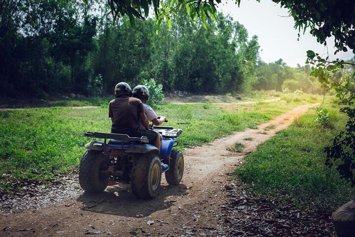 duas pessoas andando de motocicleta em uma estrada de terra