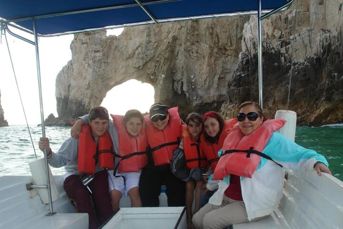 un gruppo di persone su una barca di fronte a una grotta