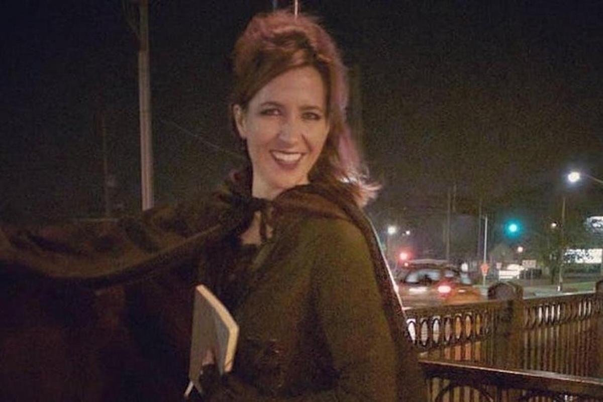 a woman is smiling while holding a book