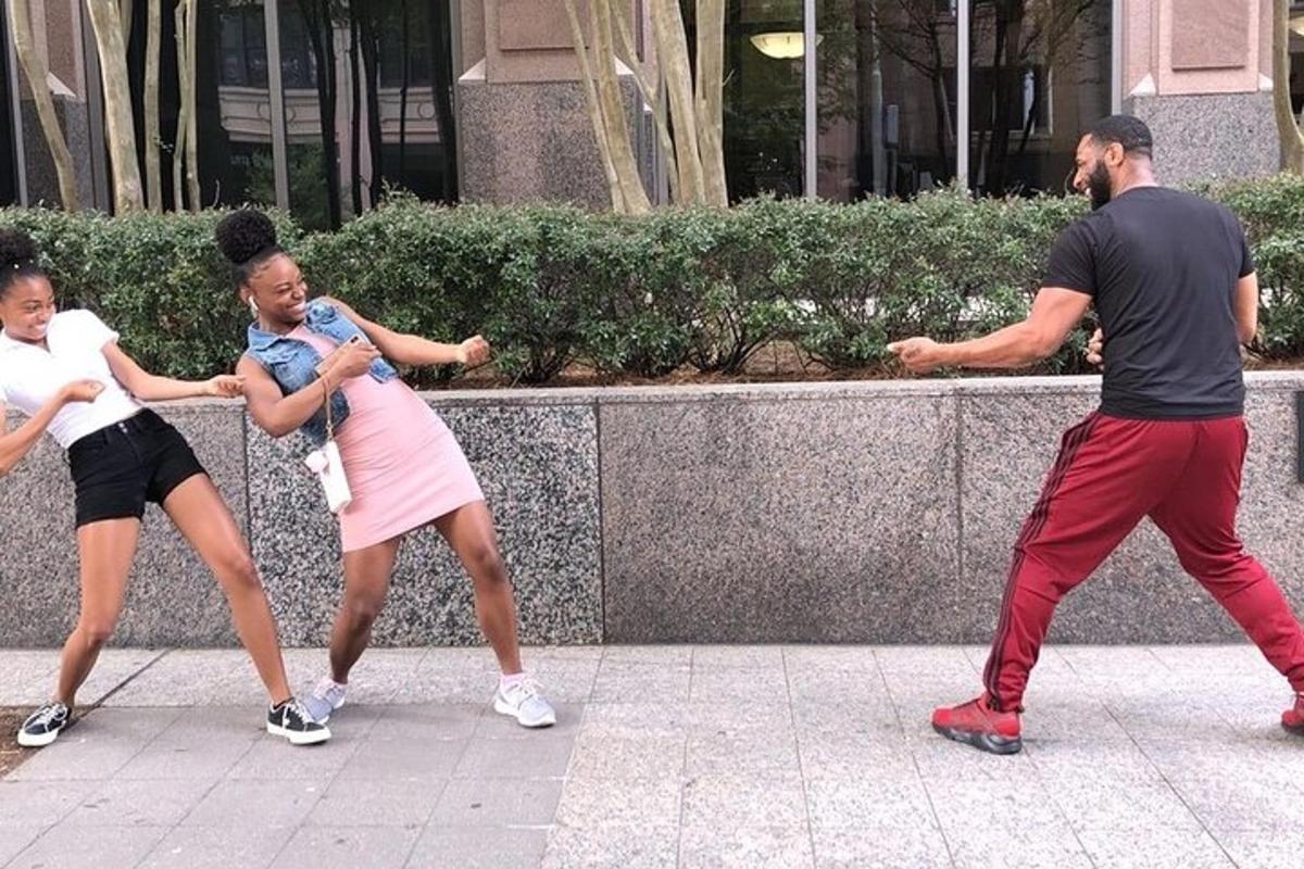 a group of people dancing on a sidewalk