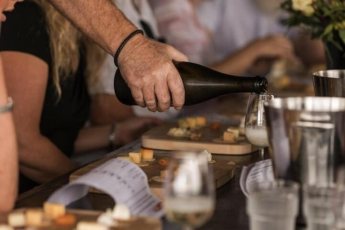 a person pouring a bottle of wine on a table