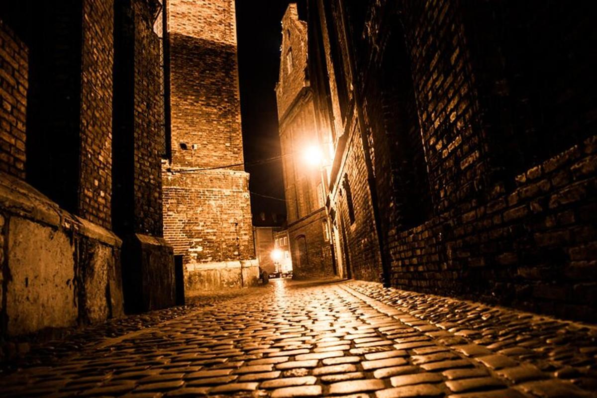 uma rua vazia à noite com uma luz na parede