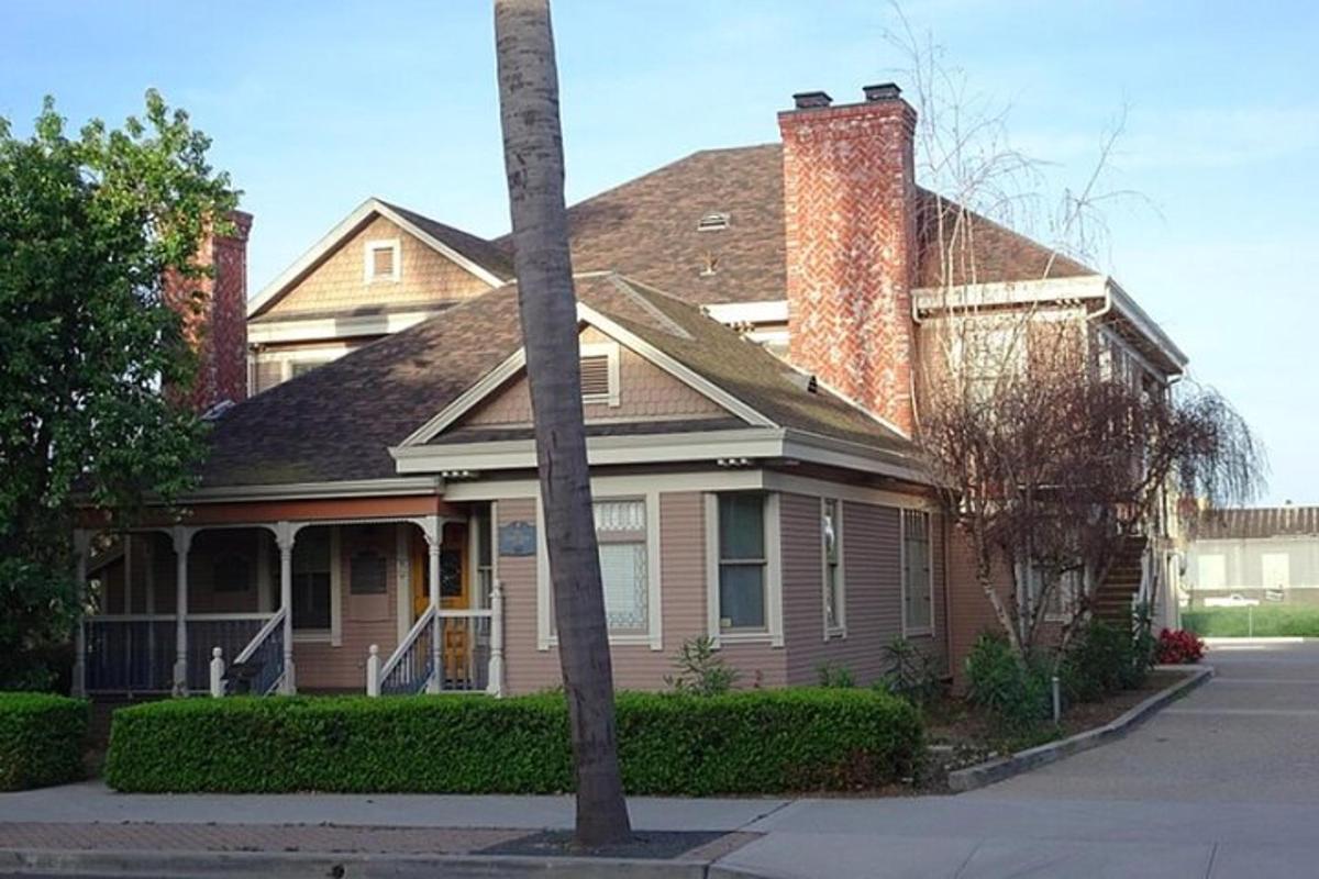 Una casa marrón con chimenea en una calle.