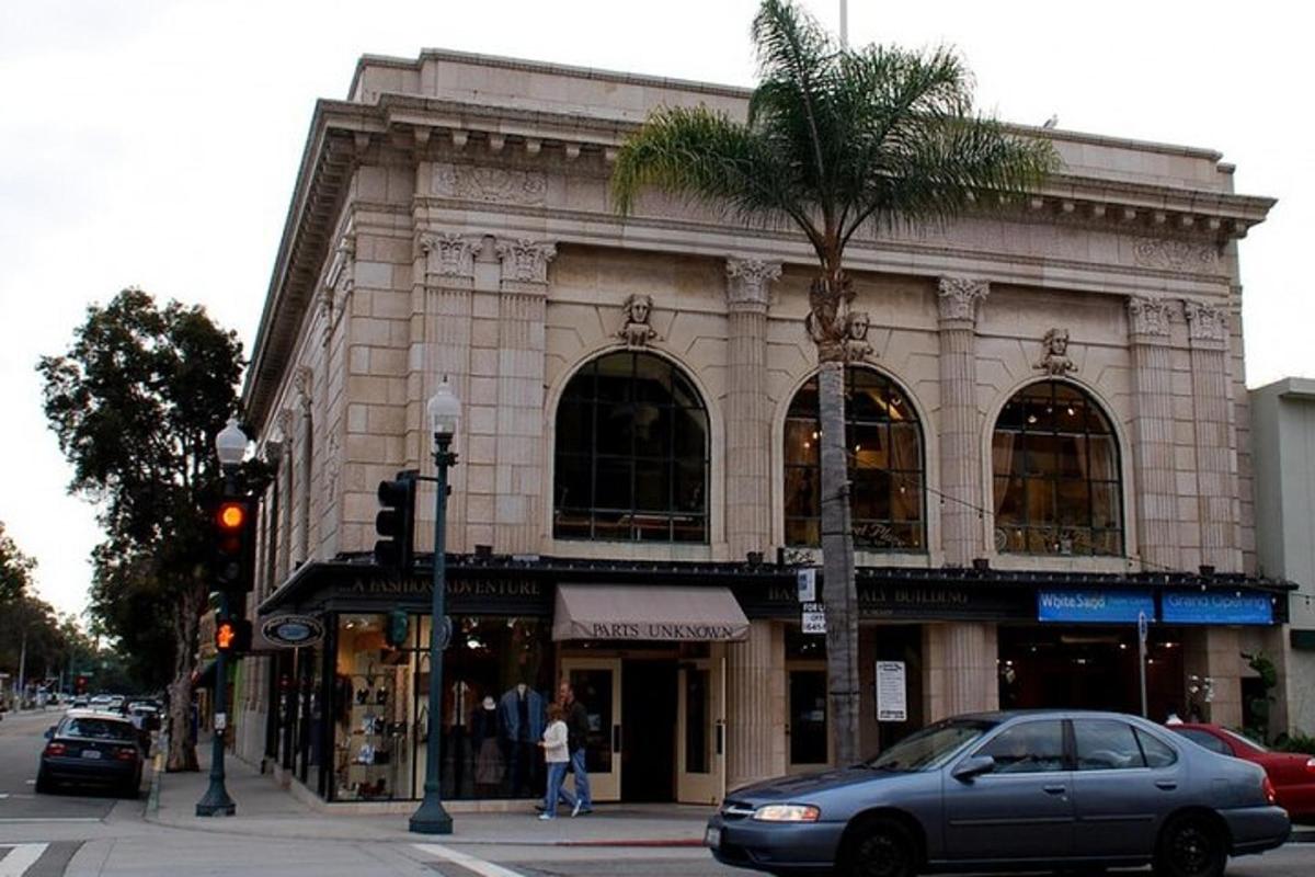 un edificio con una palmera frente a una calle