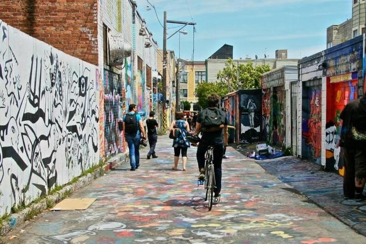 sekumpulan orang menunggang basikal menyusuri lorong grafiti