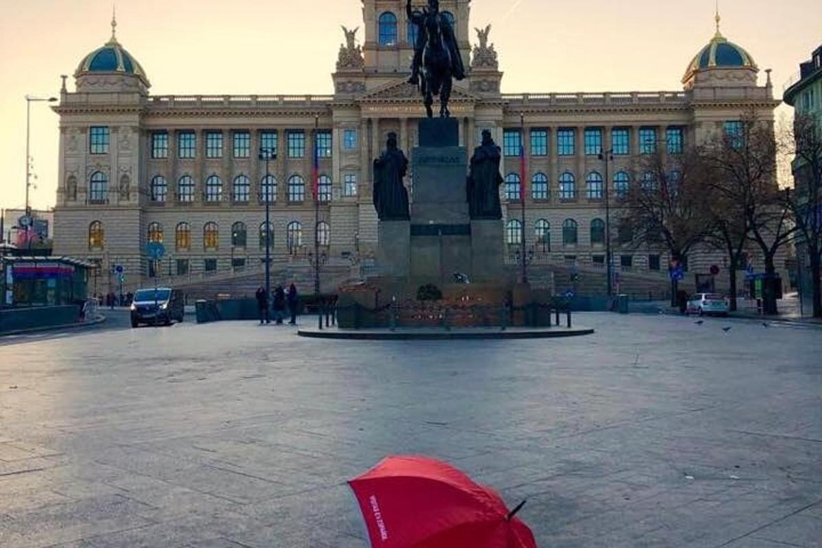 hoone ees punase vihmavarjuga inimene