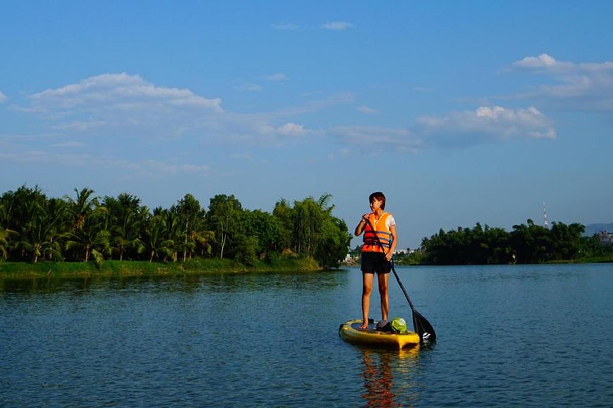 Muž stojí na paddleboardu na vodě