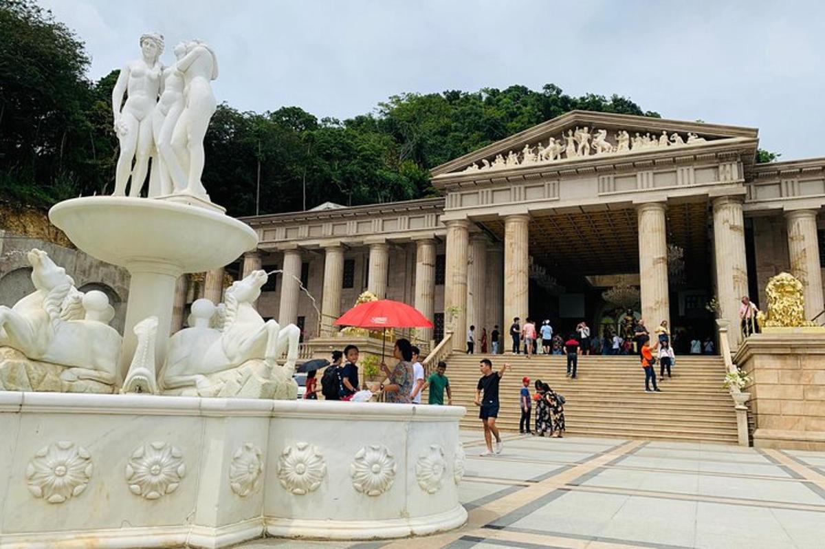 uma estátua em frente a um prédio com uma fonte