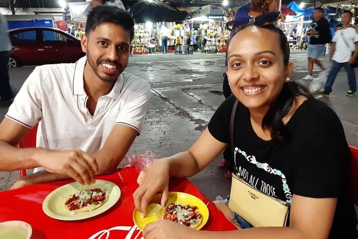 a man and a woman sitting at a table with a plate of food