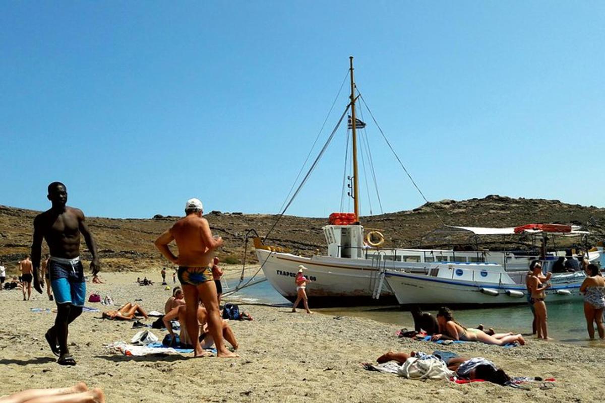 um grupo de pessoas em uma praia com um barco