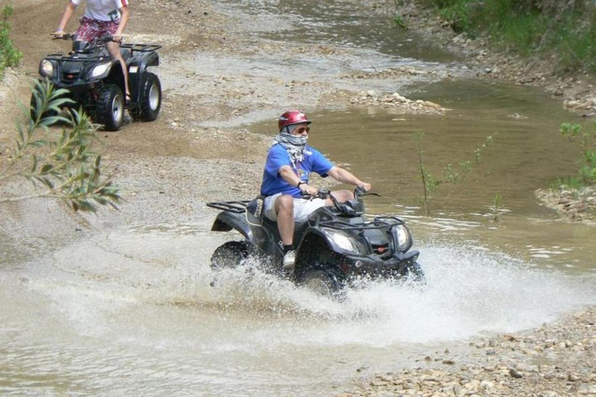 Un hombre conduciendo un quad por un río