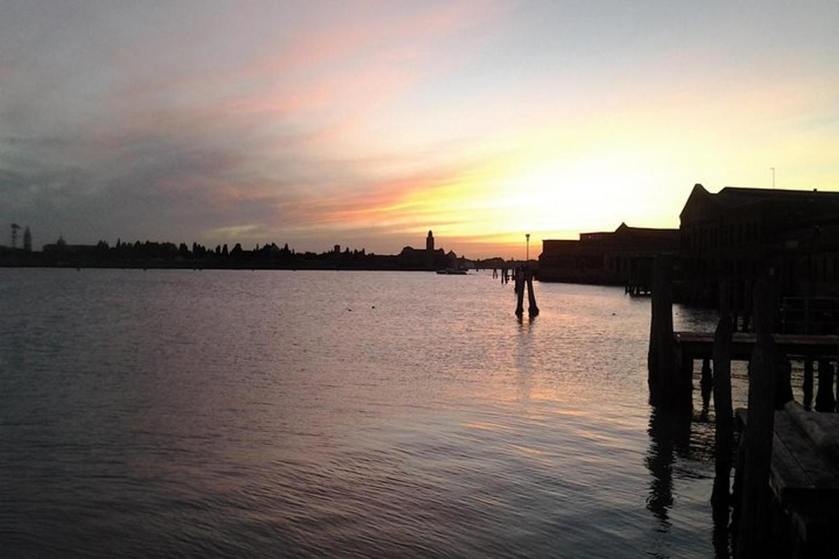 un tramonto su uno specchio d'acqua con un molo