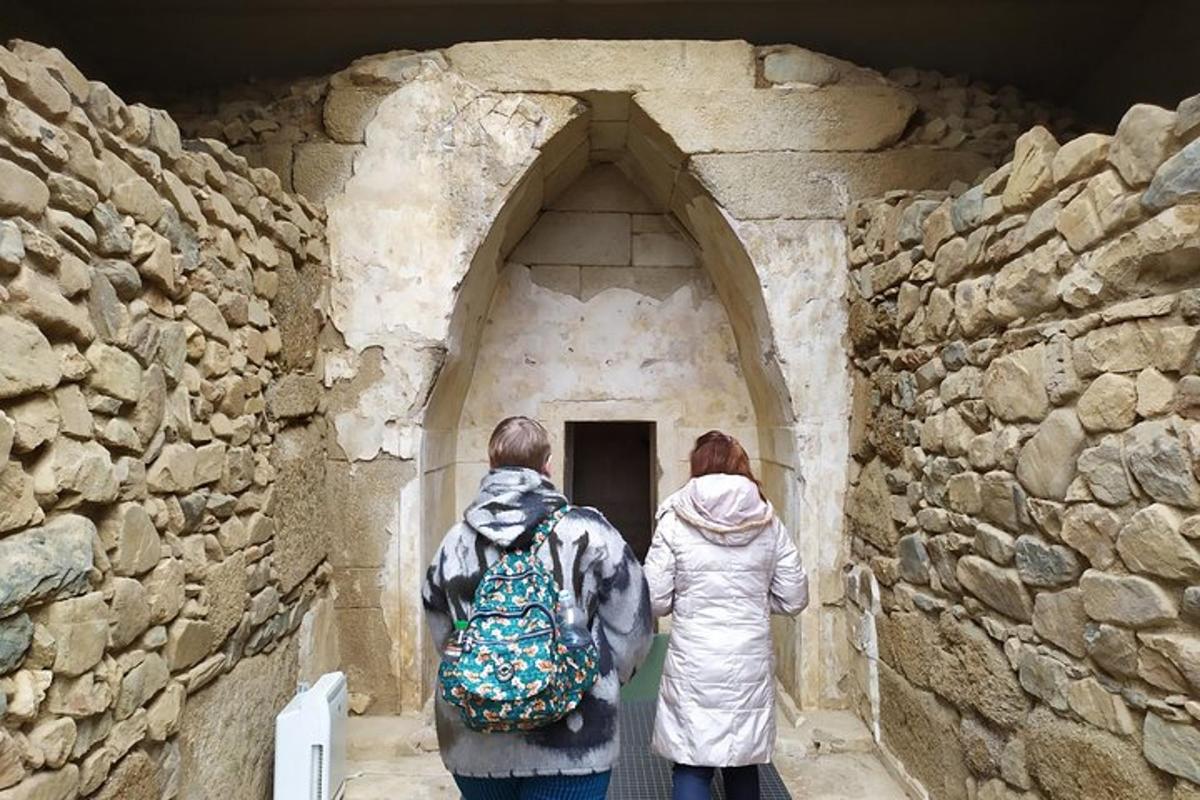 two people walking into a stone building