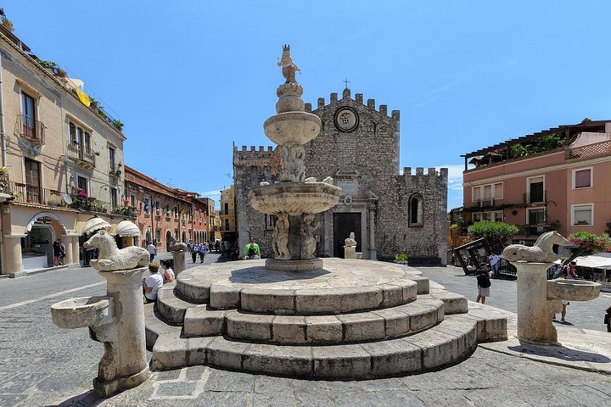 a fountain in the middle of a street with a building