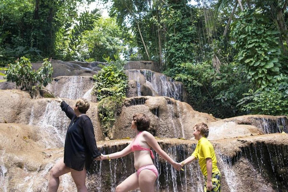 sekelompok orang berdiri di depan air terjun