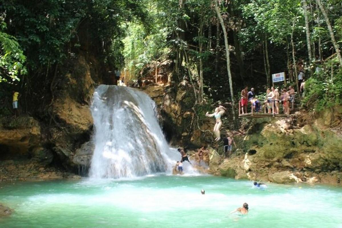 sekelompok orang berenang di air terjun