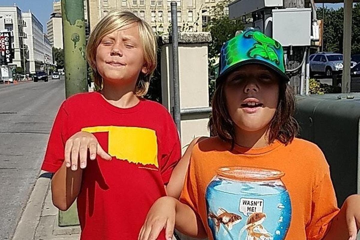 kaks noort poissi istuvad tänavanurgal purgiga