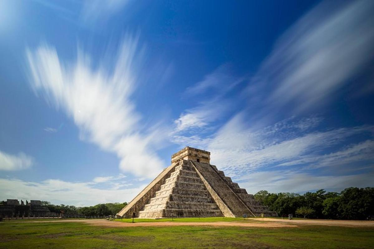 uma estrutura piramidal em um campo com céu azul