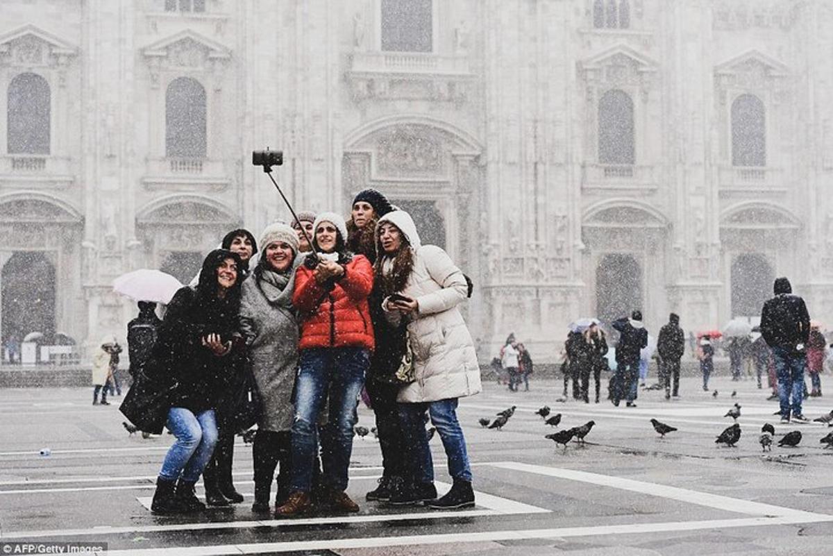 un gruppo di persone in piedi davanti a un edificio nella neve