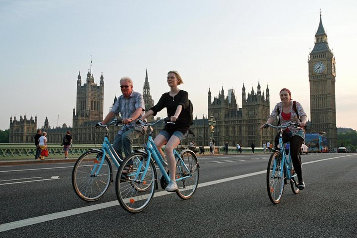 três pessoas andando de bicicleta pela rua em frente ao Big Ben