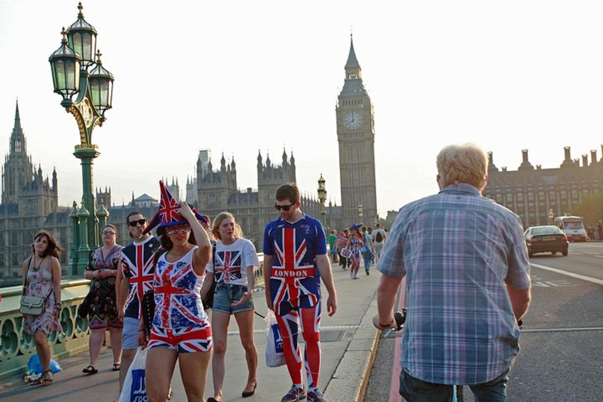 um grupo de pessoas caminhando em uma ponte com bandeiras britânicas