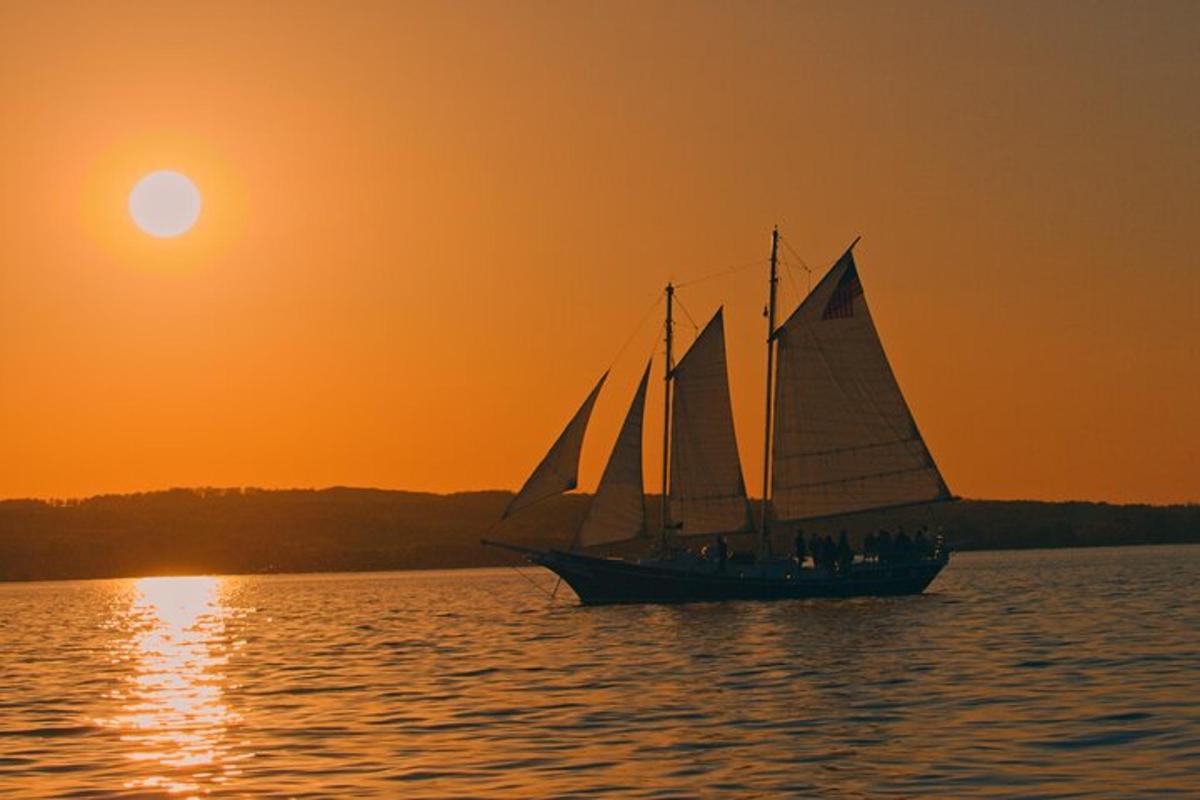 a sail boat on the water at sunset