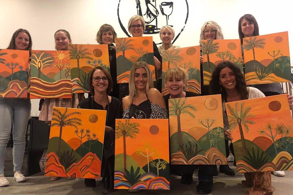a group of women holding up orange paintings