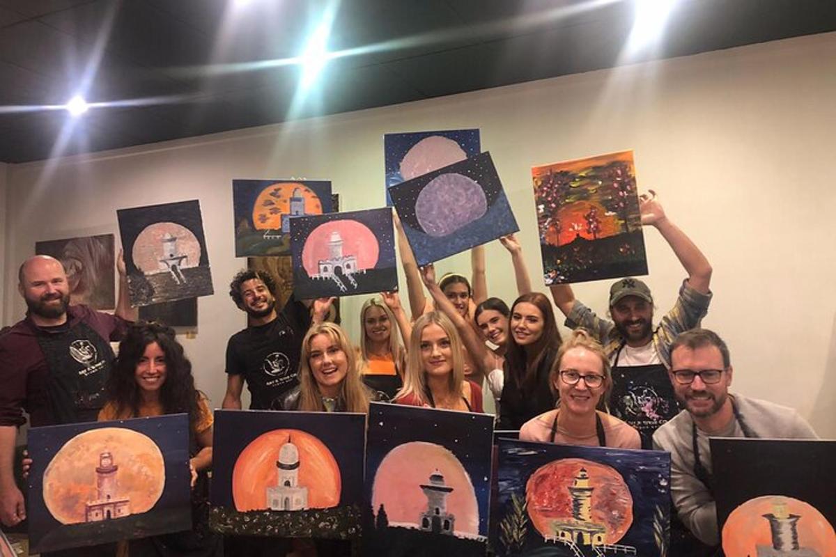 a group of people holding up their paintings
