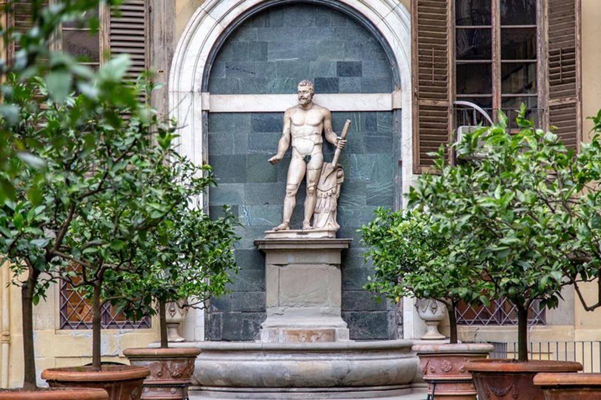 una estatua de un hombre de pie encima de una fuente