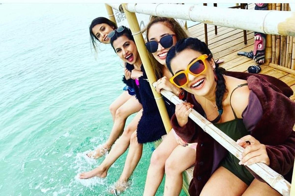 a group of girls sitting on a boat in the water