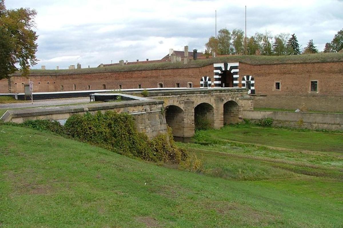 un ponte sopra un campo con un edificio in mattoni