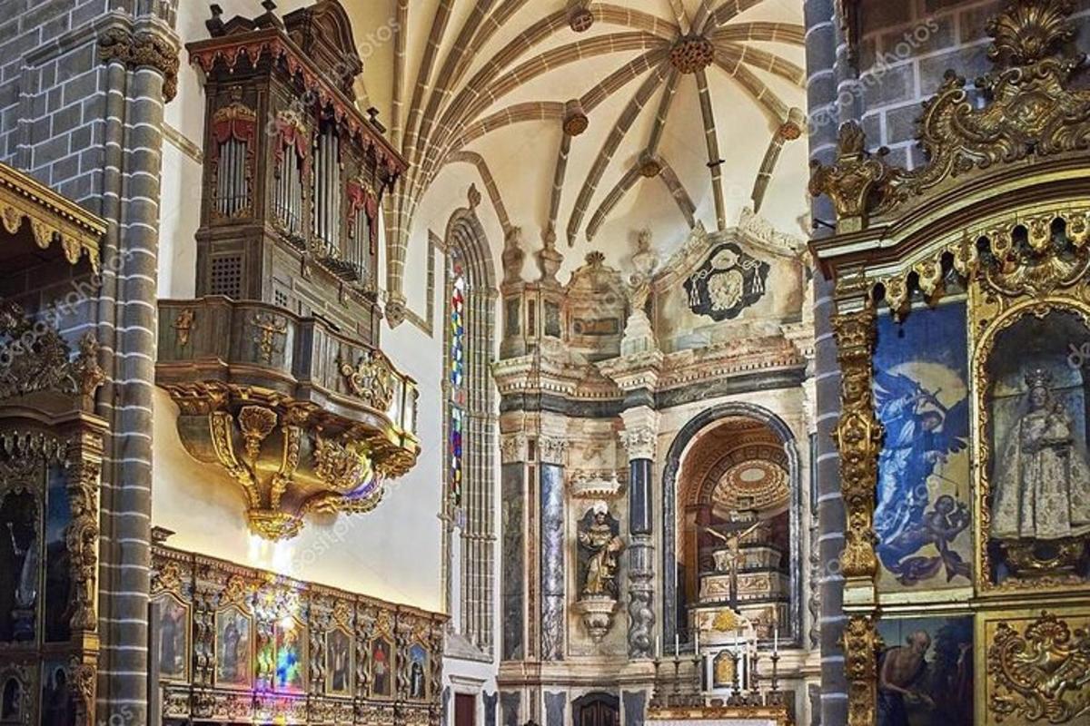 Una iglesia con un reloj y pinturas en la pared.