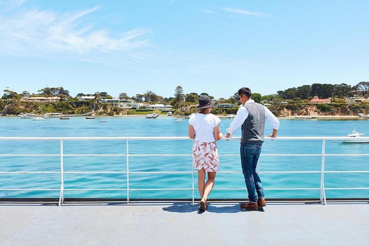 a man and woman standing on a bridge looking at the water