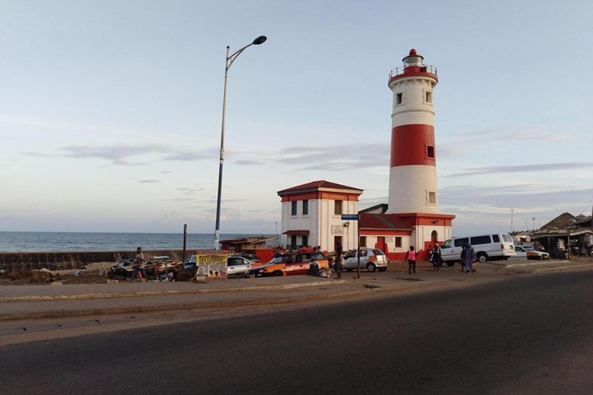 ein rot-weißer Leuchtturm neben dem Meer