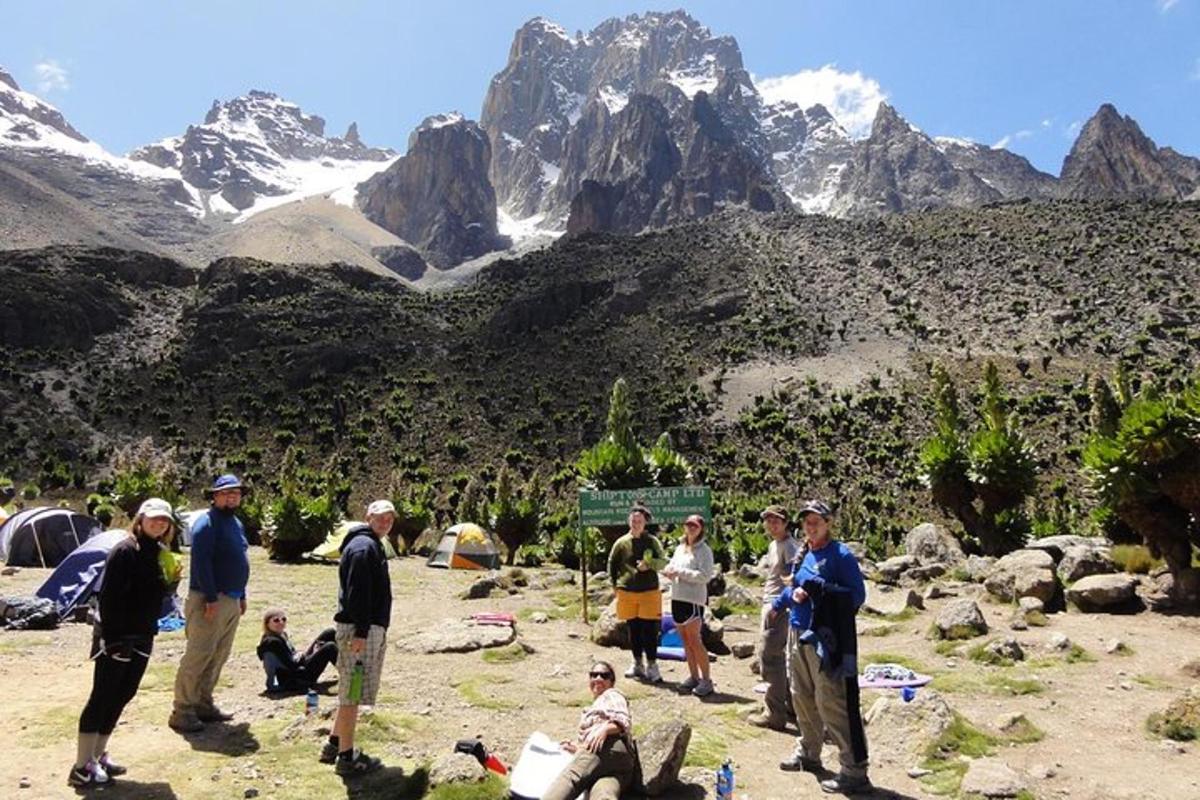 a group of people standing in front of a mountain