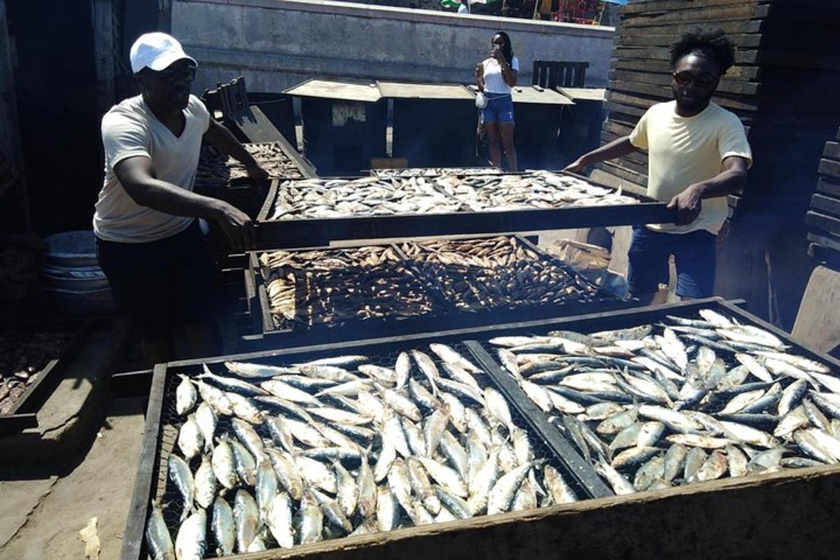 Zwei Männer bereiten auf einem Markt Fisch auf Tabletts zu