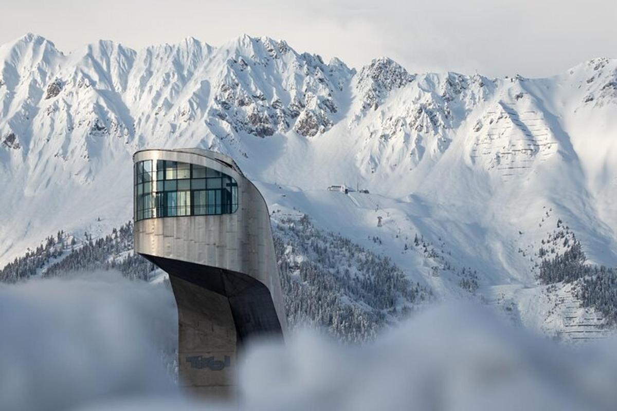a building in front of a snow covered mountain