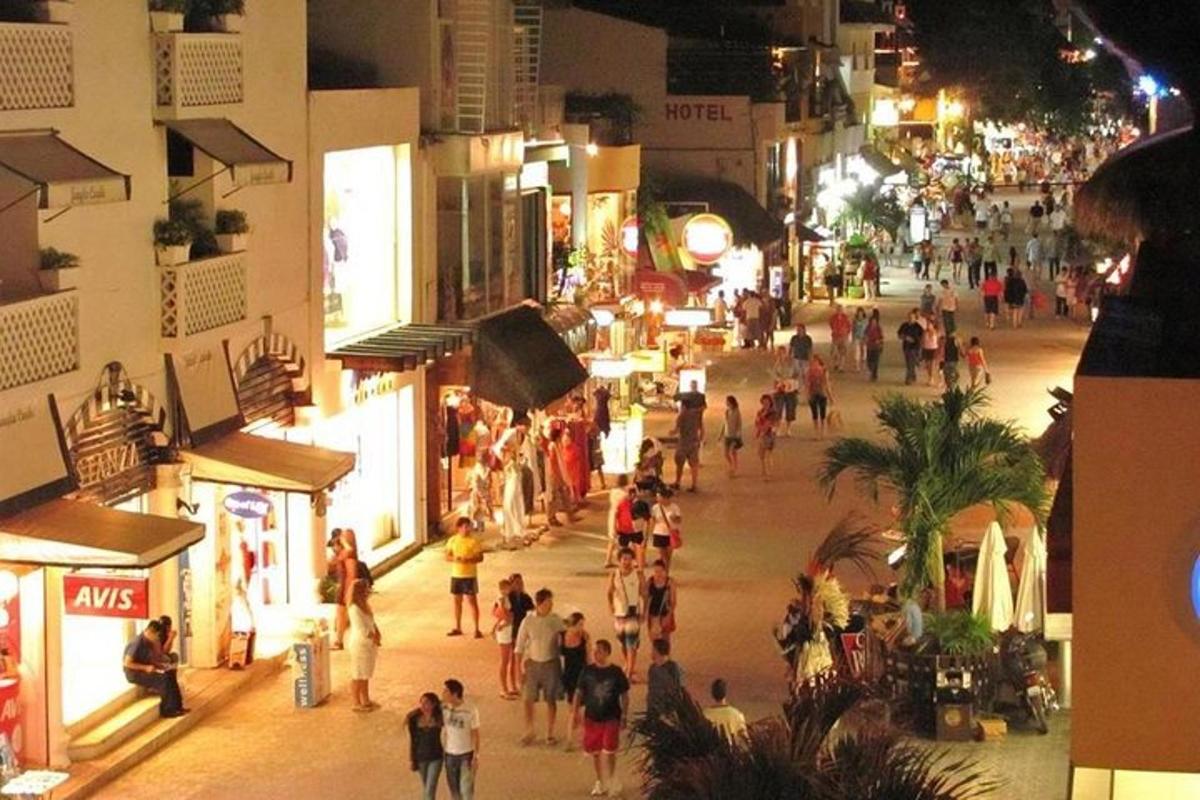 a group of people walking down a street at night